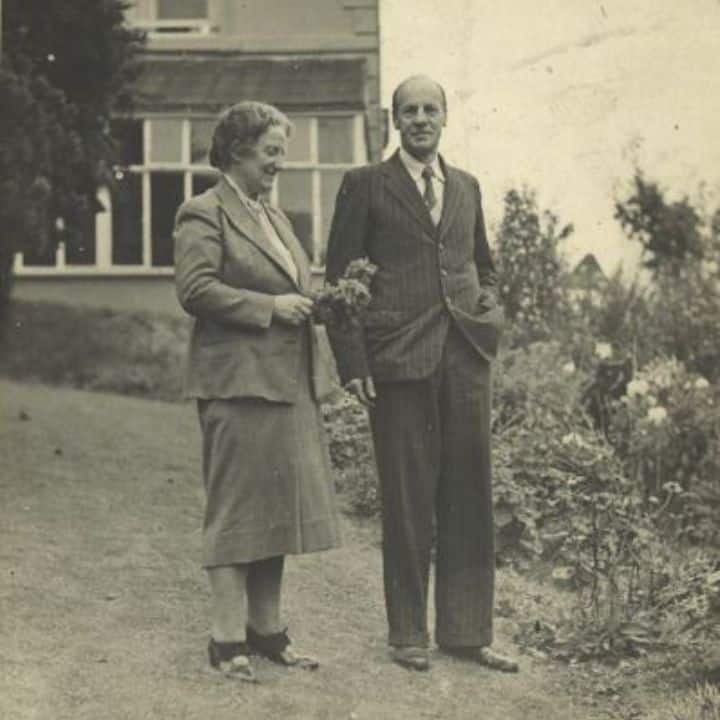 Black and white photo of a smartly dressed couple in a garden