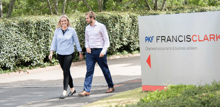 Two colleagues walking together in a green space outside the PKF Francis Clark Exeter office