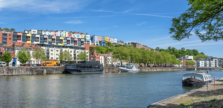 Bristol harbourside on a sunny day with boats docked and colourful buildings