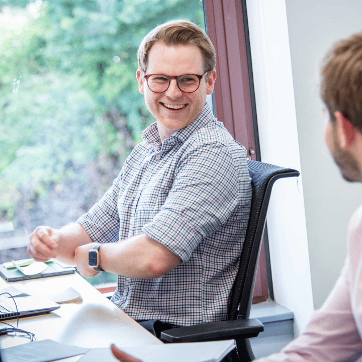 Smiling professional laughing as he works with a colleague in an office