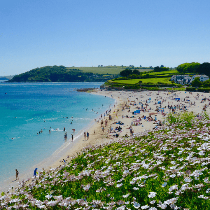 Falmouth beach with a large number of beachgoers enjoying the hot weather