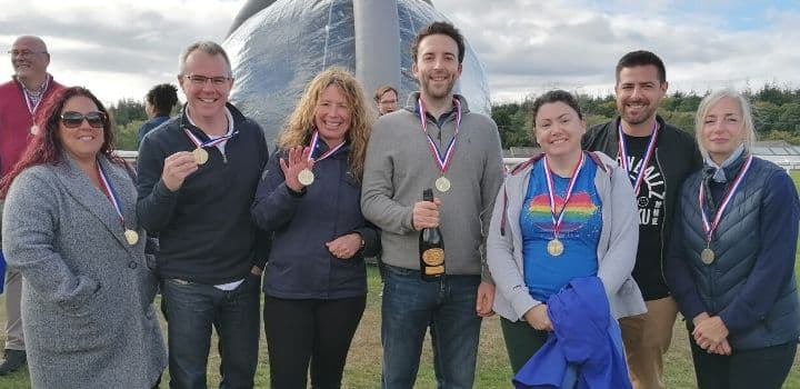 Financial Planners with champagne and medals at an away day