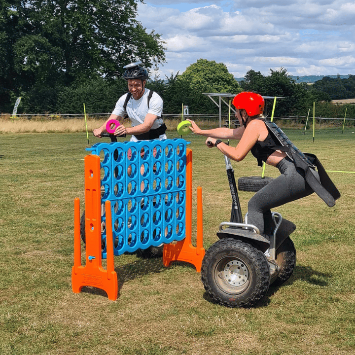 Two colleagues competing on segways during a team away day