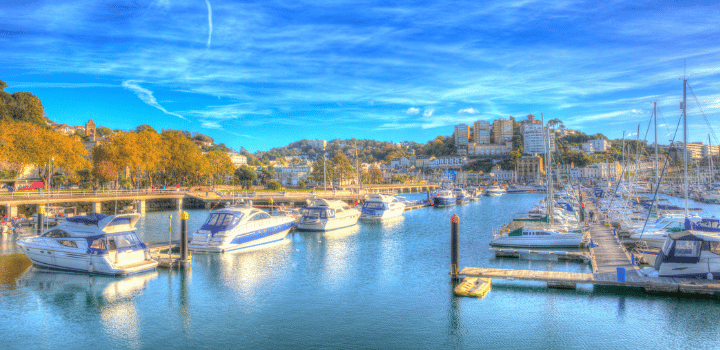 Boats moored in Torquay Harbour with the sun setting