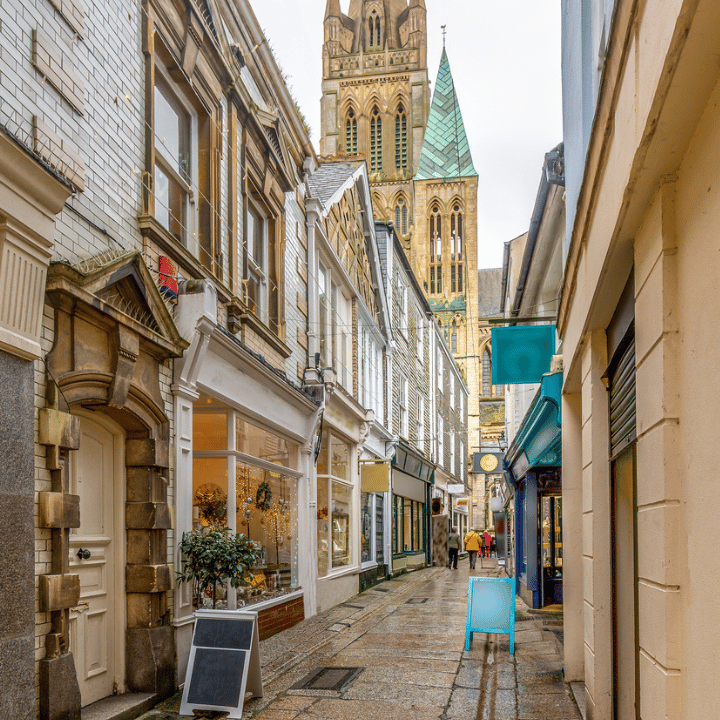 Narrow Truro street with retail shops on either side and Truro cathedral at the end